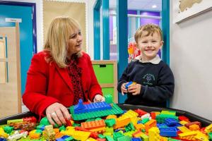 Photo of pupils and staff at Gaelscoil na gCrann welcome Education Minister Michelle McIlveen to officially open their new school.